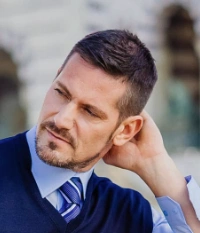 Short, textured hair with a clean, tapered style. Dark brown color, suitable for formal or casual occasions.