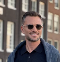 Short, textured hair with a clean fade, styled back; dark brown color; suitable for casual or formal occasions.